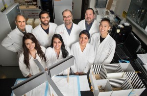 Staff, students and faculty in the College of Pharmacy, under the leadership of Associate Professor of Pharmaceutical Sciences Kabir Lutfy, pose in a research lab at WesternU with an elevated plus maze, which is used to measure anxiety, left, and a conditioned place preference apparatus, which measures the preference of animals for one chamber over the other and is used to measure the rewarding and aversive effects of different compounds. From front left: Angel Garcia; Prableen Singh, MSPS '15; Anita K. Ahoura and Arthur Chen. Back row: Abdul Hamid; Osman Farhad; Kabir Lutfy and Paul V. Marquez. (Jeff Malet, WesternU)