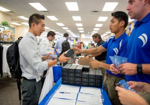 First-year COMP student Jin Lee, left, receives his new SonoSim ultrasound training probe and software from SonoSim intern Matt Marcelino Wednesday, August 3, 2016 at the WesternU Bookstore during Welcome Week. (Jeff Malet, WesternU)