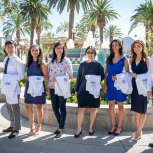 students standing and smiling with white coat