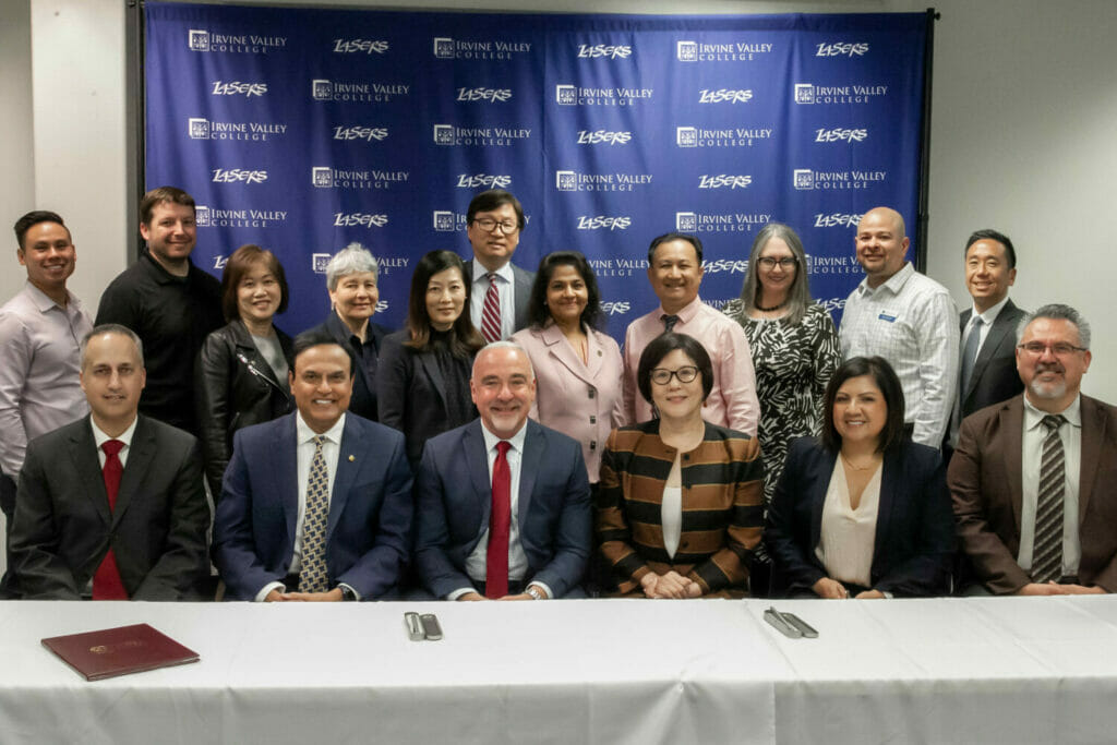 Group photo of several people sitting and standing in two rows.