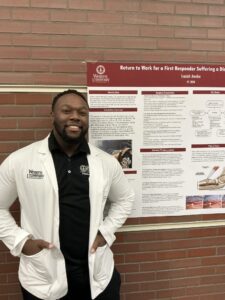 A man in a white coat stands and smiles in front of a research poster titled "Return to Work for a First Responder Suffering a Distal Biceps Tendon Rupture" at Western University.