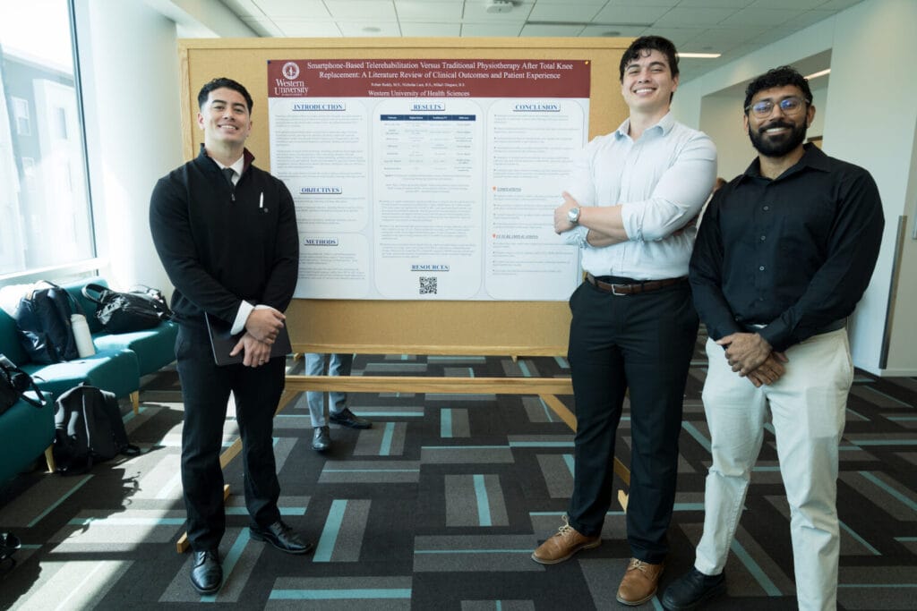 Three men stand in front of a research poster displayed on a board in a well-lit indoor setting.