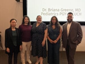 Five people standing side by side in front of a screen displaying the text "Dr. Briana Greene, MD Pediatrics PGY-LUCH.