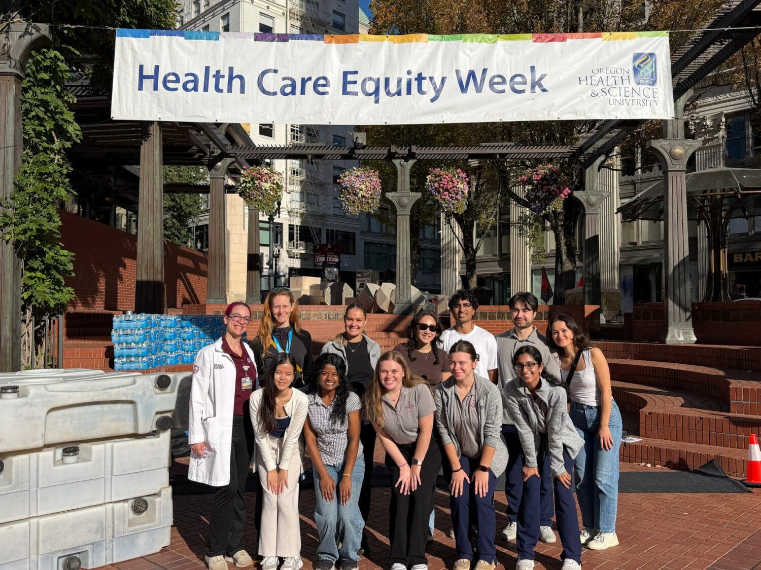 A group of people standing in front of a banner that reads “Health Care Equity Week” at Oregon Health & Science University.
